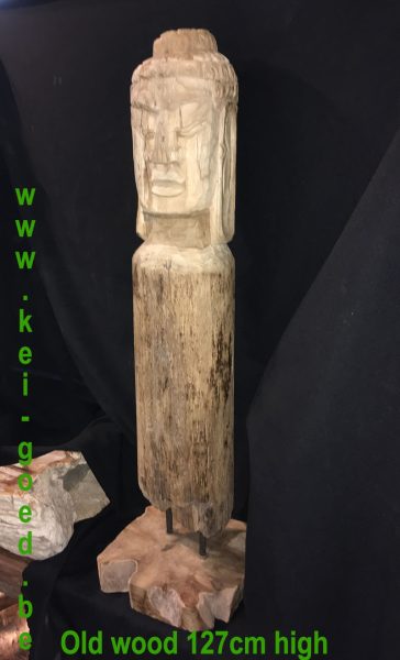 Afbeelding van Boeddha op een oude houten staander van een stal voor een karbouw.